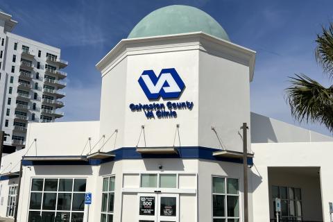 White building with blue and white accents and a green dome roof.