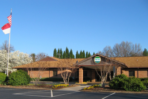 Brown building, flag, and trees.