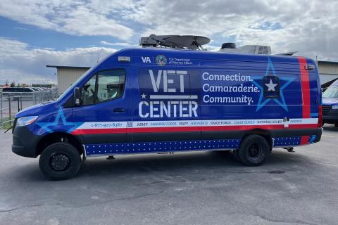 Blue van with "VET CENTER" and stars, parked outdoors.