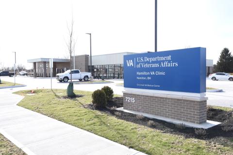 Blue sign for VA Department of Veterans Affairs near hospital entrance.
