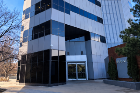 Tall office building with glass windows and entrance.