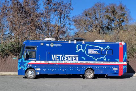 Blue and red van with "VET CENTER" text parked on road.
