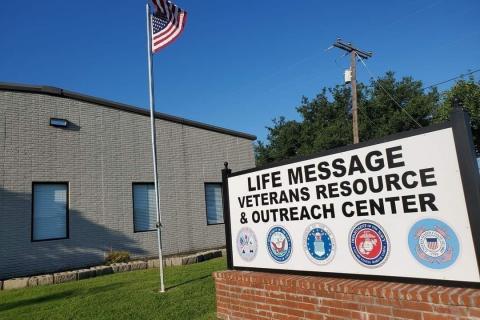 Life Message Veterans Resource and Outreach Center sign in front of gray building with American flag.
