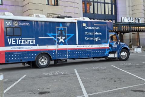 Blue and white Vet Center mobile unit parked in city lot.