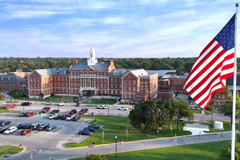 Aerial view of a large government building with an American flag.