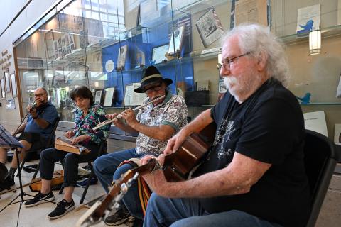 Four musicians playing instruments in a museum setting.