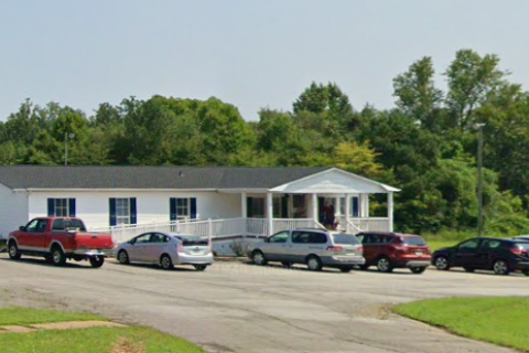 white building with trees in the background