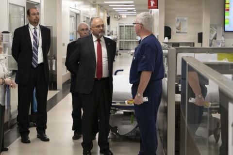 Group of formally dressed men in a hospital hallway.