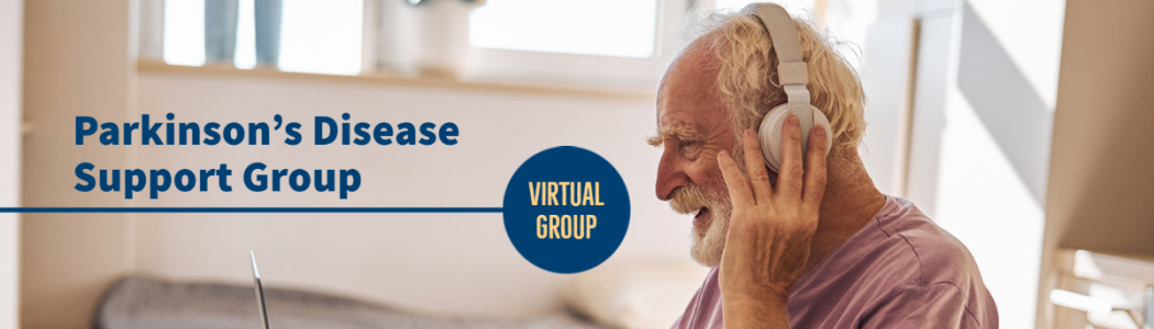 photo of a person with white hair and beard sitting in a wheelchair with headphones and a laptop
