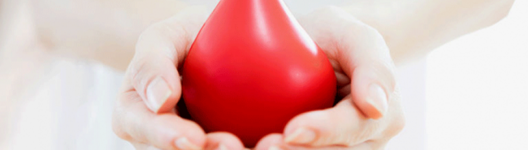 Person holding a red stress ball shaped as a blood drop.