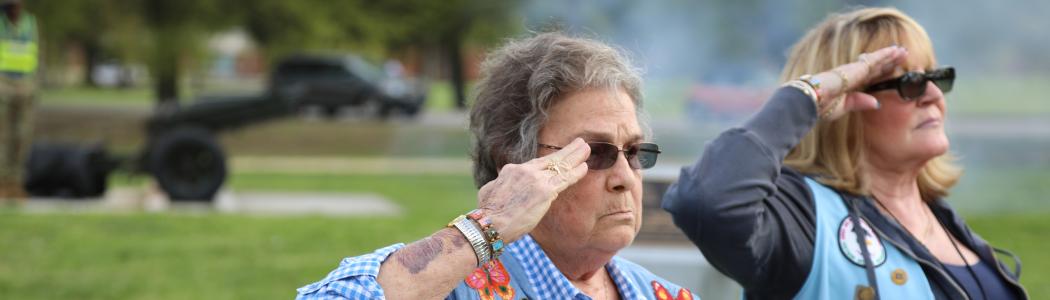 Two women Veterans render a salute.