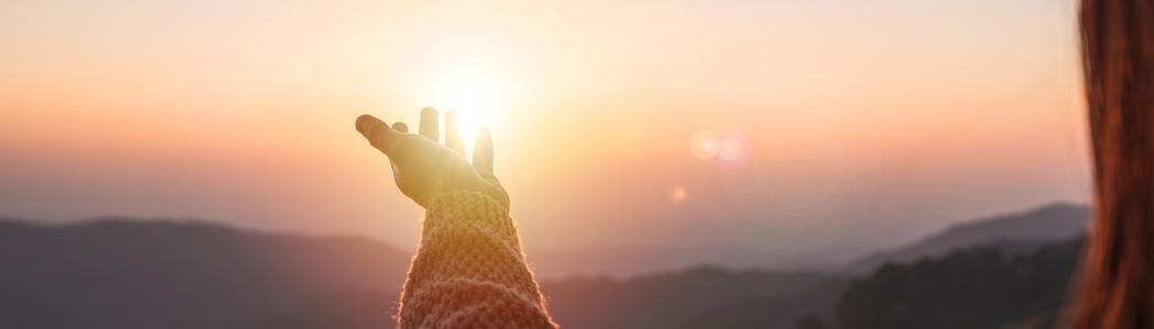 Hand reaching out to the light in hope