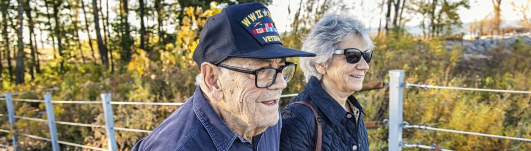 WWII Veteran walks outdoors with his daughter.