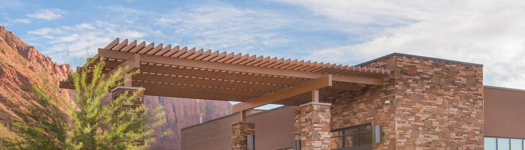 Sandstone building with tree in front
