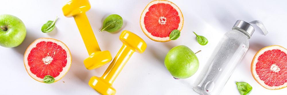 Fitness and healthy food lifestyle concept. Dumbbells, diet fruit, water on white background