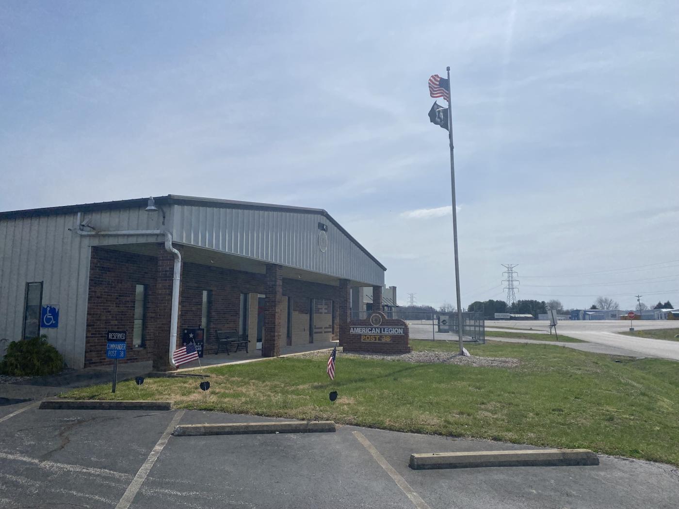 Photo of metal building with brick face and flags flying at front.