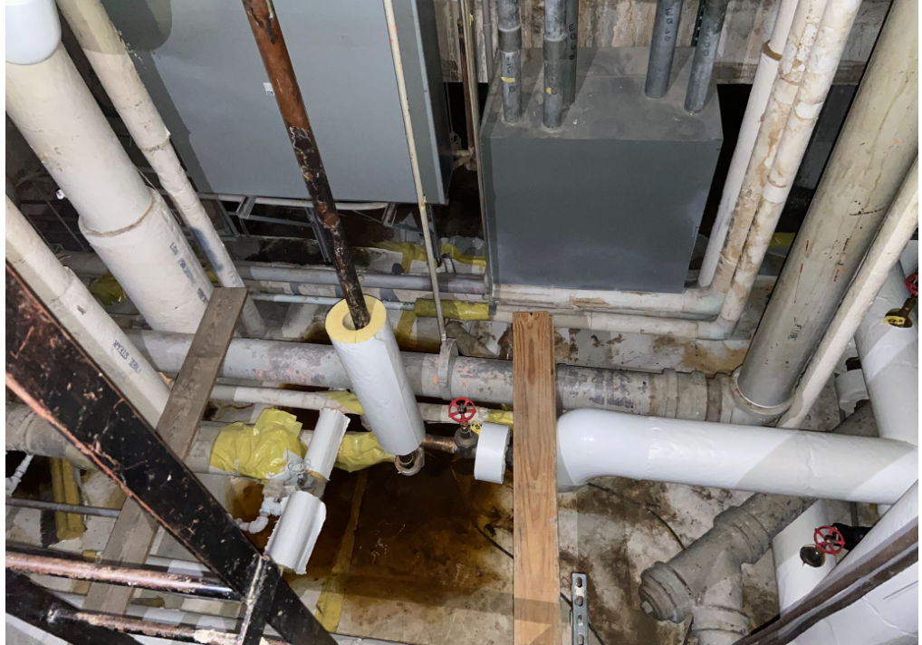 Photo of confined space BK-03-B004A-PRCS, mechanical space; entry into sub basement. Located in Pharmacy storage room; open space entry with vertical ladder.