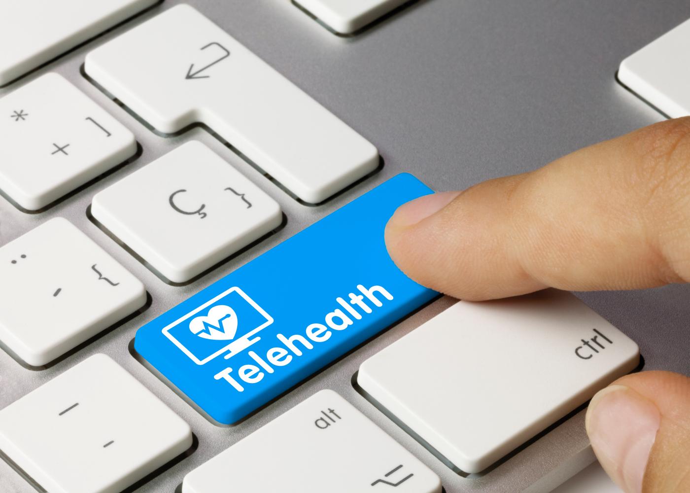 A button labeled Telehealth is pressed on a keyboard.