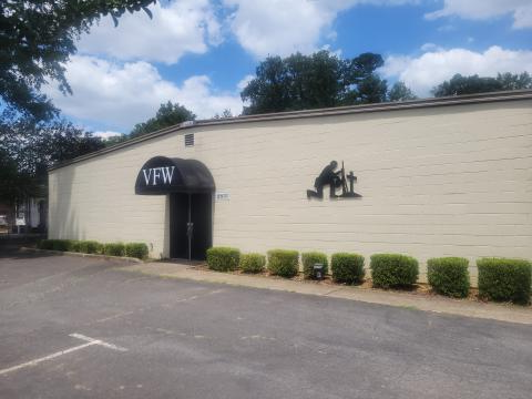 Tan building with kneeling soldier and VFW at the entryway