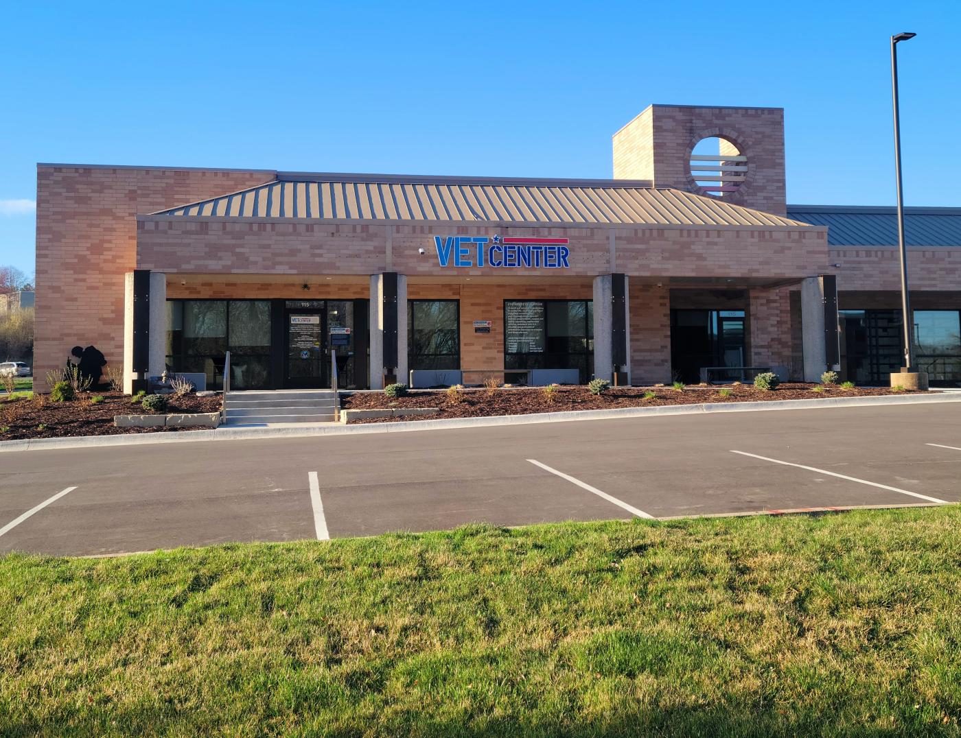 The Vet Center sign on the outside wall, to the right of the main entrance and front steps faces the parking lot. Handicap parking is to the right.