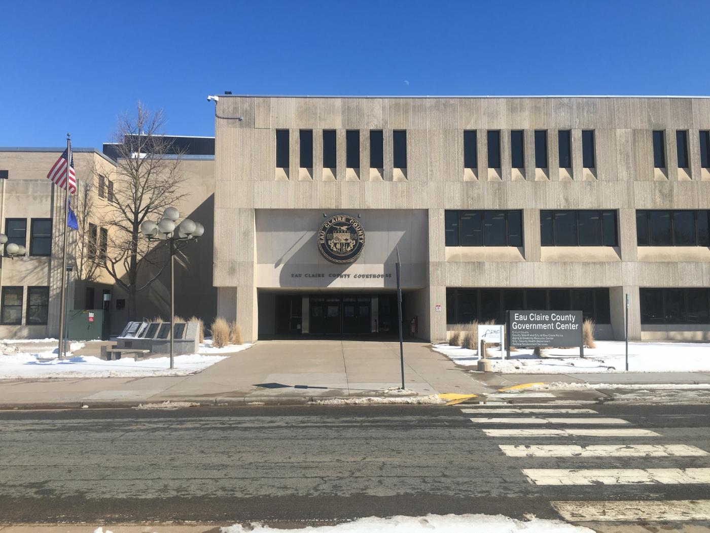 Cement building with Eau Claire County Courthouse Emblem above the four door entrance. Walk in the main entrance and look for County Veteran Services.