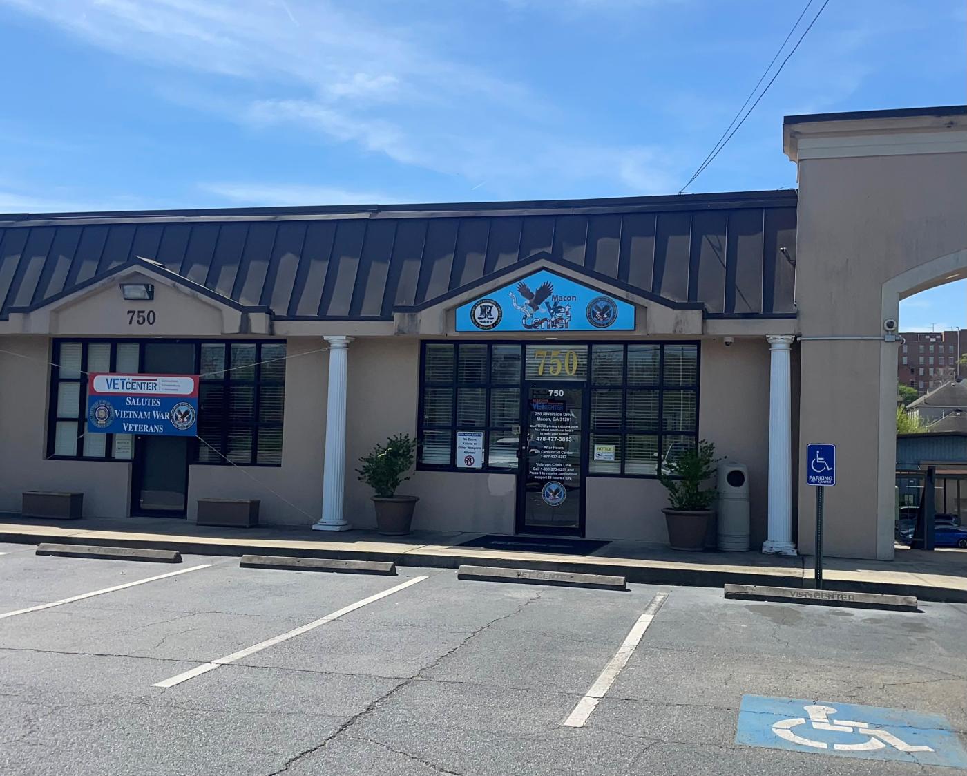 A building with a clear blue sky in the background. There is a blue sign that says Vet Center on the front of the building and the number 750.