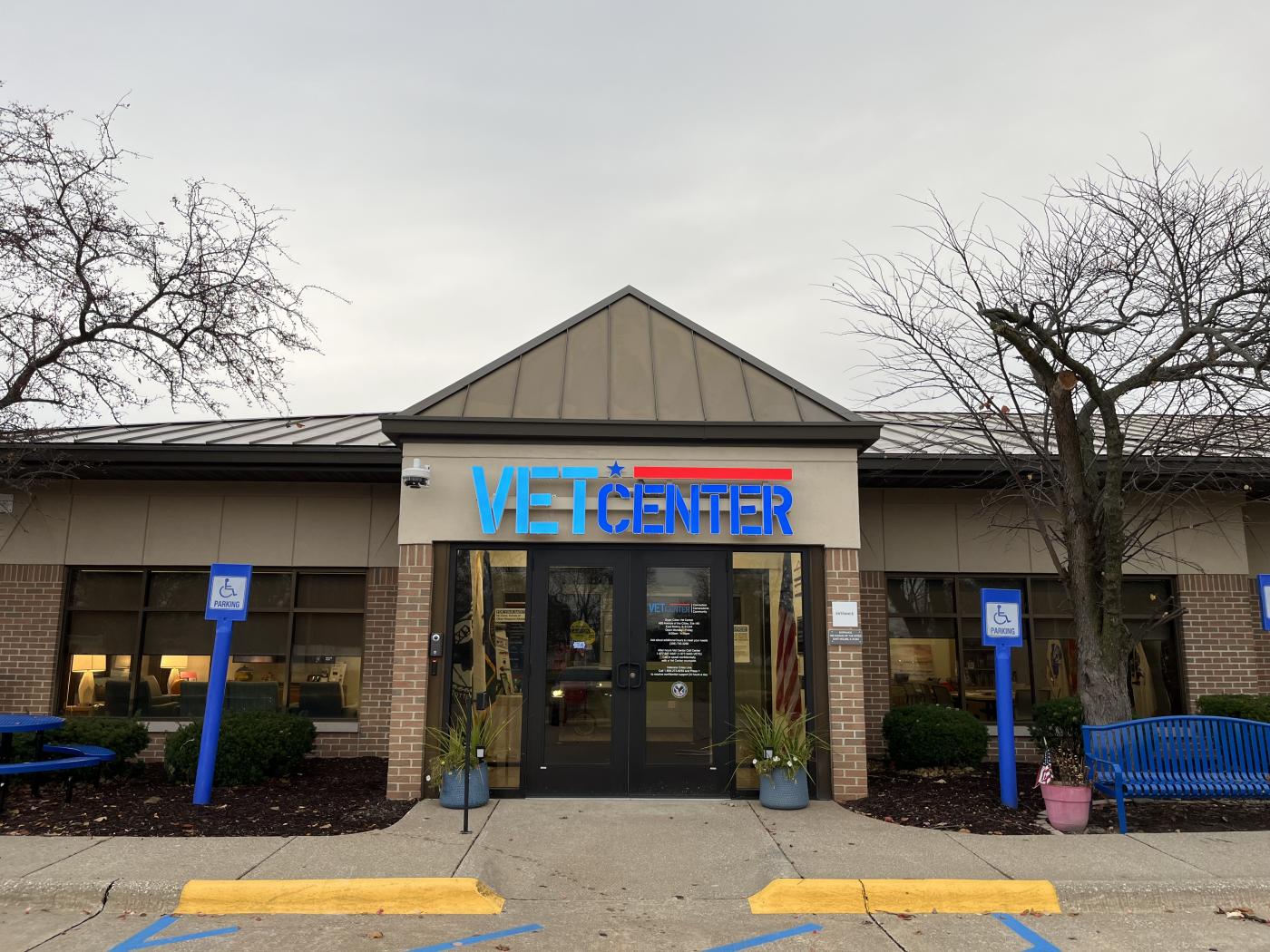 Vet Center building with blue and red logo, surrounded by trees and blue benches.