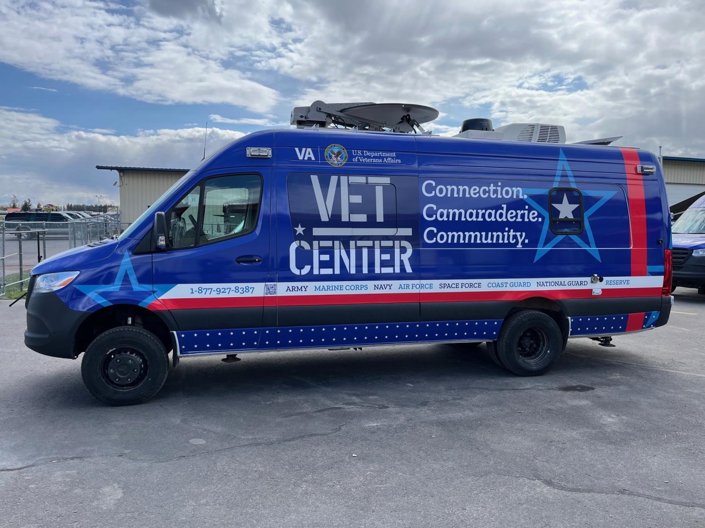 Blue van with "VET CENTER" and stars, parked outdoors.