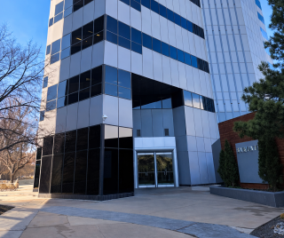 Tall office building with glass windows and entrance.