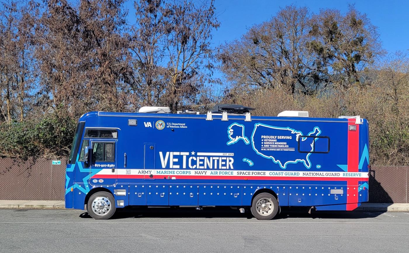 Blue and red van with "VET CENTER" text parked on road.