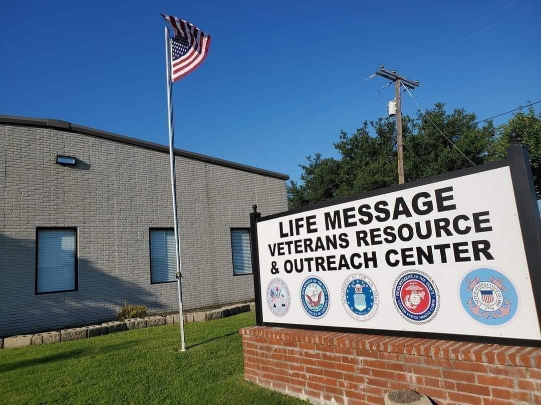 Life Message Veterans Resource and Outreach Center sign in front of gray building with American flag.