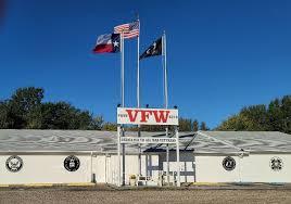 VFW building with three flags and a blue sky.
