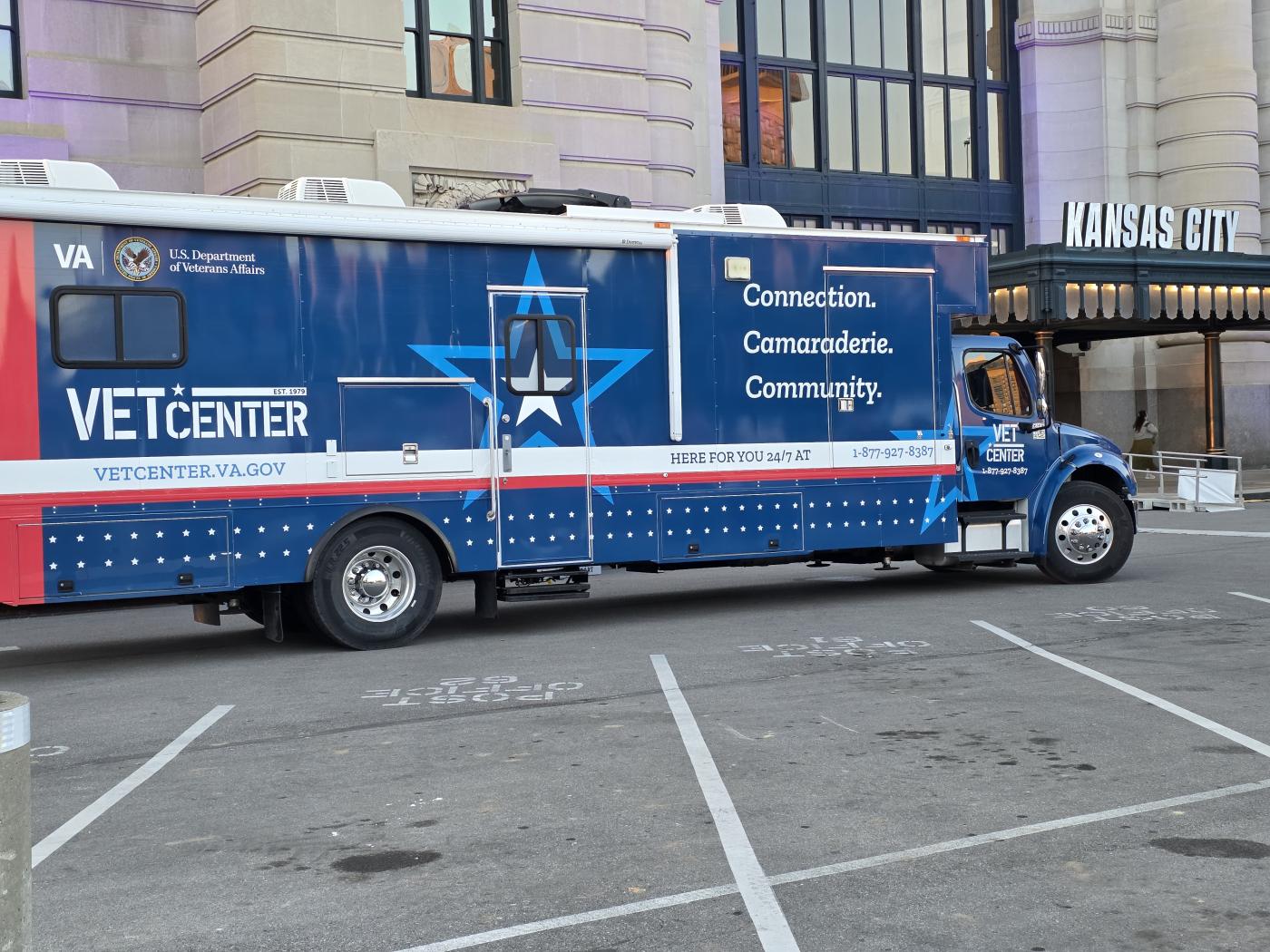 Blue and white Vet Center mobile unit parked in city lot.