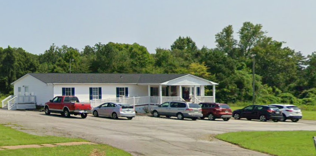 white building with trees in the background