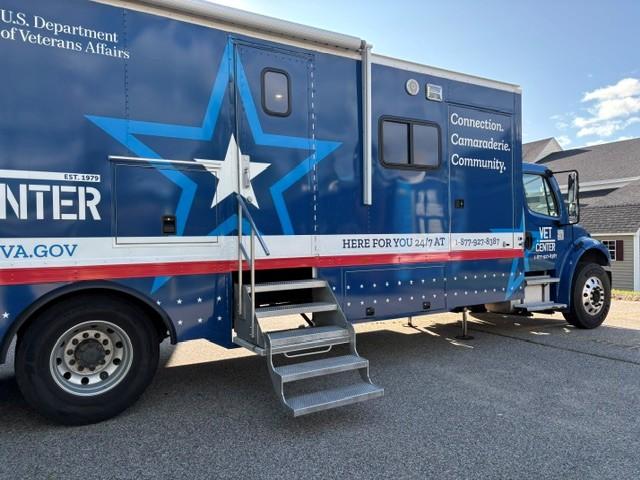 Blue and white mobile unit with star graphic, parked on pavement.