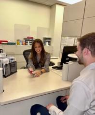 Woman smiling at man across desk in office setting.